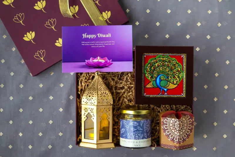 Gift box embossed with a company logo beside a branded card and champagne ribbon